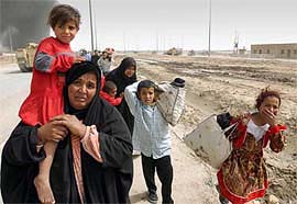 A family of Iraqi civilians takes cover as people fleeing Basra in southern Iraq on Monday