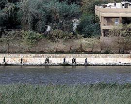 Iraqi soldiers run out of President Saddam Husseins palace in Baghdad on Monday as US troops take control of the main presidential palace