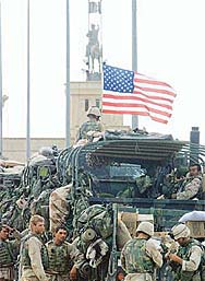 Soldiers of the US Marine Corps stand in front of Saddam Husseins main palace in Tikrit 