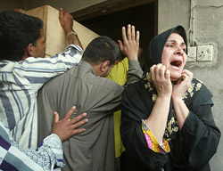 An Iraqi woman grieves as five coffins are brought to Zaafaraniya, a suburb of Baghdad, after an explosion at an ammunition depot on Saturday.