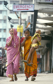 Two women and a girl cover their faces as they pass the city hospital in Kolkata on Sunday where a SARS patient is admitted.