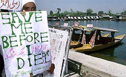 A veiled Kashmiri girl holds a placard during a "Save Dal" protest on the banks of the Dal Lake in Srinagar