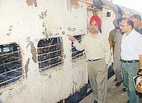 Railway Safety Commissioner Bhupinder Singh inspects the burnt coaches of the Amritsar-bound Golden Temple Express