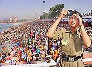 As thousands of devotees take a holy dip in the Brahm Sarovar, a lady constable of the Haryana Police looks at the solar eclipse 