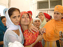 A crying Madhvi, a victim of the 1984 riots, is consoled just before ardas at Akal Takht on Monday.