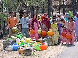 Residents of Chhatrali village in Hamirpur district on Sunday wait on the roadside for the water tanker.