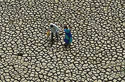 A couple on their way home take a short cut on the broken dry bed 