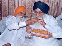 Mr Gurcharan Singh Tohra offers a ladoo to Mr Parkash Singh Badal 