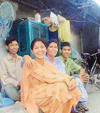 Tulsa, daughter of a Nepali watchman, is all smiles as she sits with her mother and brothers after topping in the 10+2 examination 