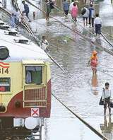 A local train makes its way along flooded tracks near Mumbai central station on Friday. 