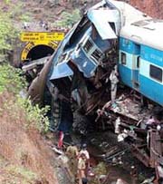 Rescue workers gather at the site of the derailed train near Kankavali
