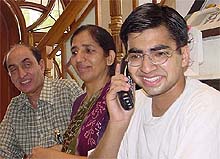 Brijesh Takkar (extreme right) attends to telephone calls as his parents look on. 