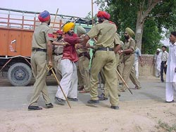 The police detain an Akali worker after the killing of a Congress polling agent