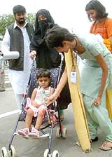 A representative of Indian business organisations presents a rose to 7-year-old Aisha, who arrived with her parents, at the Wagah check post 