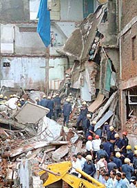 Rescue workers remove the debris of a collapsed building after a powerful explosion at Varachha in Surat on Sunday
