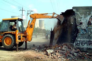 Municipal Corporation workers demolish permanent structures on the Santpura road in Bathinda