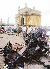 The mangled remains of a taxi destroyed in a bomb blast lies in front of the Gateway of India in Mumbai on Monday. 