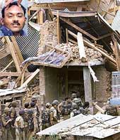 Soldiers walk amid the debris of a house immediately after it was blasted by troops 