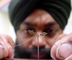 Jaspal Singh, who recently entered the Guinness Book of World Records for making the smallest book, shows another of his creations, micro kites made of wood which he passed through the needle through a 1mm hole