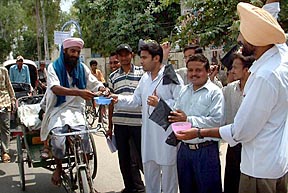 Members of B.Ed Unemployed Teachers Front (Punjab) beg alms from a rickshaw-puller