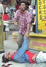A civilian lends a helping hand to a critically injured person at Lal Chowk in Srinagar after a grenade blast on Thursday.