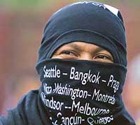 A protester covers his face with a shirt listing the sites of previous demonstrations