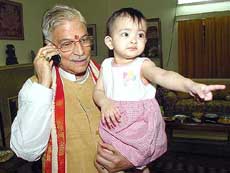 A visibly relieved Dr Murli Manohar Joshi answers a phone call while holding his grand-daughter at his residence in New Delhi on Tuesday.