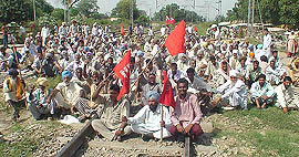 Agitators squat on the railway track as a part of the state-wide protest against government policies in Phillaur on Tuesday.