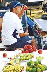 A half-eaten apple in his right hand and a ball in the left, Sachin Tendulkar watches the proceedings from the stands of the cricket stadium at Mohali