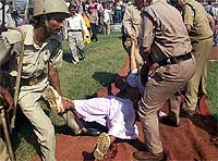Policemen carry one of the activists