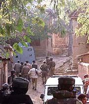 Security forces enter Tharan village, 60 km south of Srinagar, during a standoff with militants who held eight persons hostage on Monday.