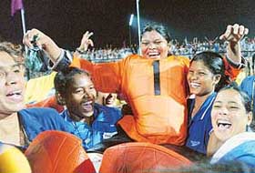 Indian players lift goalkeeper Helen Innocent (C) after their victory over South Africa
