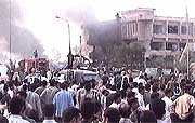 A video image shows crowds watching smoke billowing into the sky