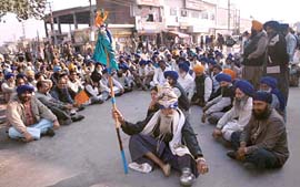 A Nihang  with a flagpole sits in  dharna at Nawanshahr during the rasta roko agitation by Shiromani Akali Dal workers on Sunday.