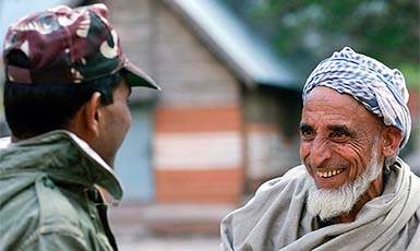 An elderly Kashmiri villager and an Indian Army soldier chat at a village in Odusaa, near Srinagar