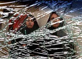 Iraqi women are seen through the broken window of their car after a car bomb suicide attack near Baghdad on Monday
