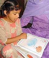 Mobin reads a Hindi primer at Jammu where the decks have been cleared for her repatriation to Pakistan 