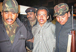 Policemen escort Joydeb Roy, alias Tom Adhikari, chief of the Kamtapuri Liberation Organisation, a separatist rebel group with bases in Bhutan, at a police camp in Binnaguri, 110 km north of Siliguri, on Saturday.