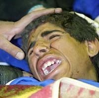An injured Iranian man cries out in pain in a mosque in Kerman on Saturday after an earthquake struck Bam, 1285 km southeast of Teheran, on Friday.