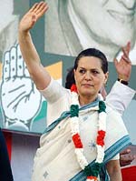 Congress President Sonia Gandhi sports a garland as she waves to party workers at a rally in Mumbai on Friday.