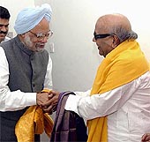 Congress emissary Manmohan Singh and DMK President M Karunanidhi shake hands as their parties decide to go for an electoral alliance