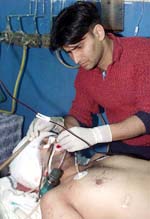 A doctor tends to an injured man after a grenade blast in Jammu on Friday.
