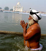A devout Sikh takes a dip at the holy sarovar at a Muktsar gurdwara on the occasion of Maghi Mela