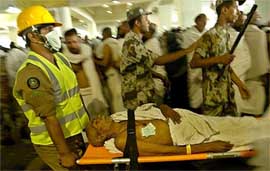 Saudi medics carry an injured pilgrim in Mena during the third day of the Haj