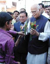 Deputy Prime Minister L.K. Advani is presented with a flower by a child during the opening ceremony of "Swasthya Mela" 