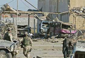 US soldiers survey the damaged police station in the town of Iskandariya, Iraq, on Tuesday