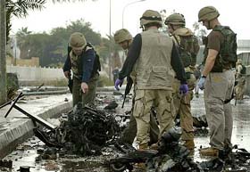 US army investigators survey the scene in front of the bombed Iraqi army recruitment centre in Baghdad