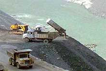 Trucks unload industrial waste into the Sutlej