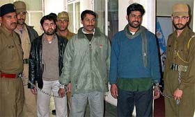 Policemen escort three suspected militants, who were arrested on charges of planning to attack Indira Gandhi International Airport