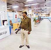A policeman stands guard inside a deserted State Bank of India branch during a strike in New Delhi on Tuesday.